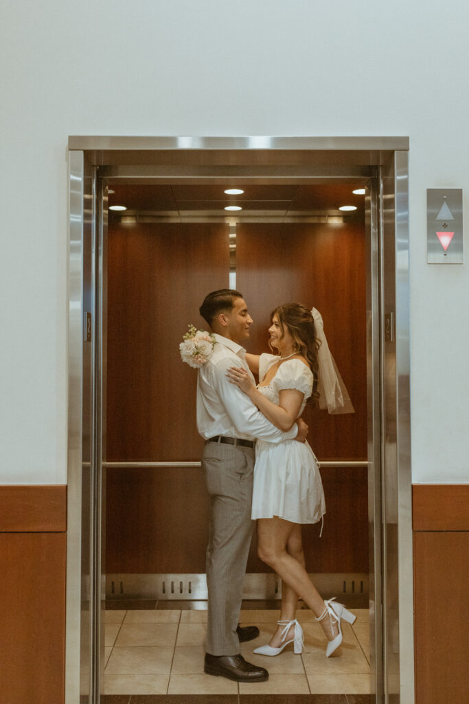 Couple inside an elevator located inside a courhouse.