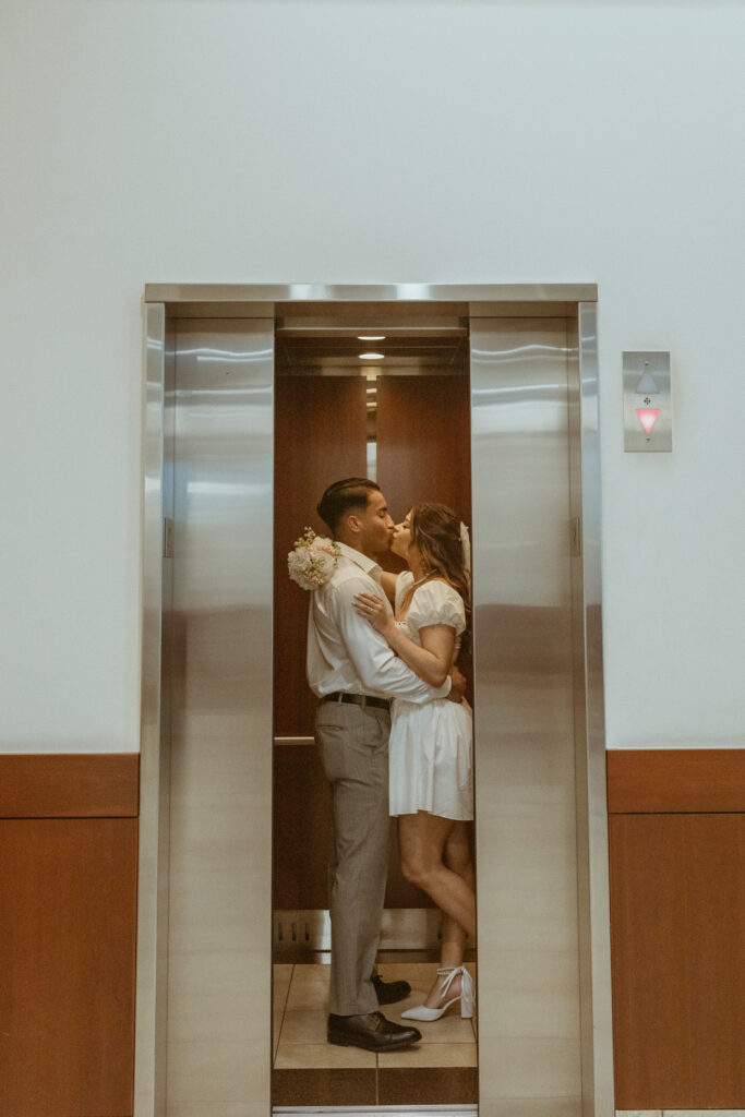 Couple kissing in an elevator at courthouse.