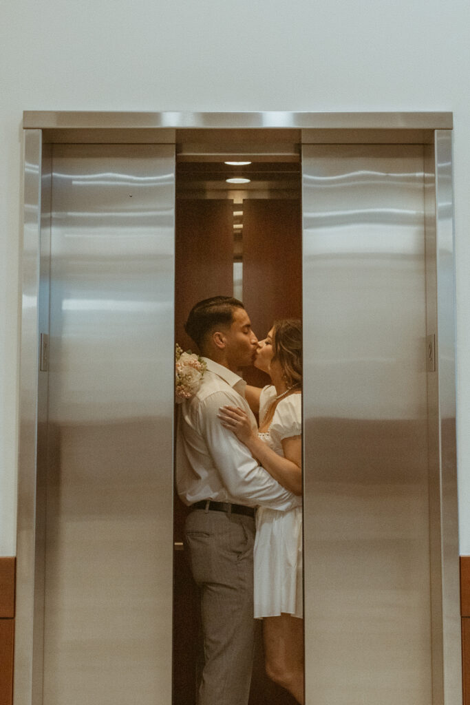 Couple inside the elevator, while doors closing, during their courthouse elopement.