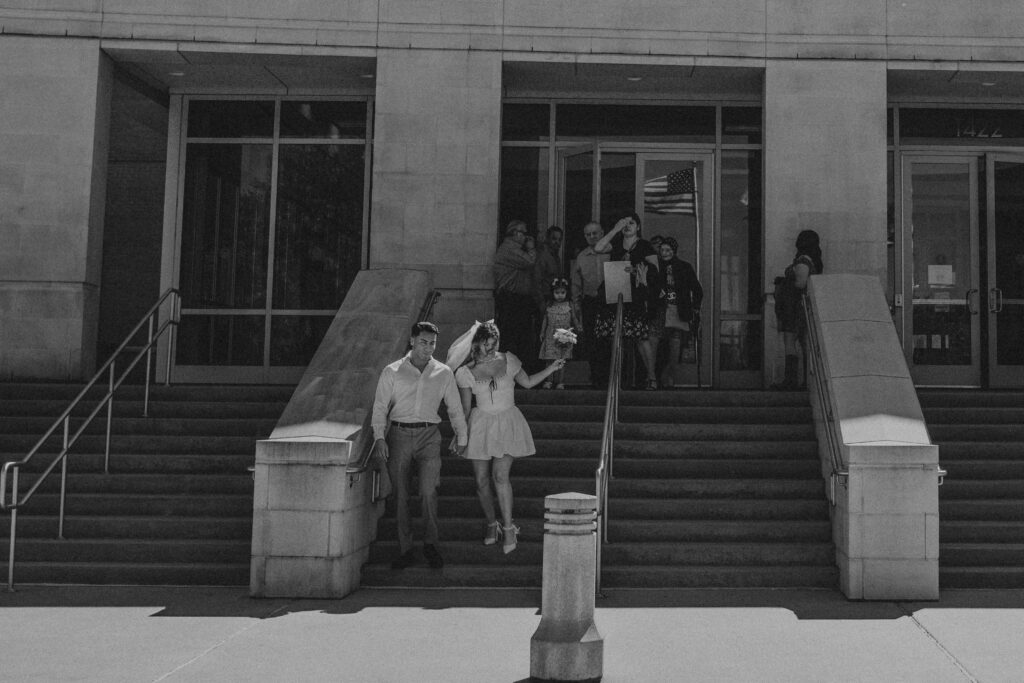 A couple walking down the stairs of a courthouse.
