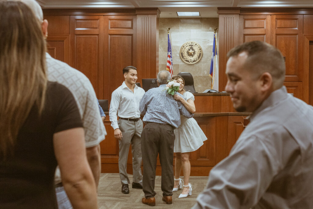 Family members hugging inside a courtroom.