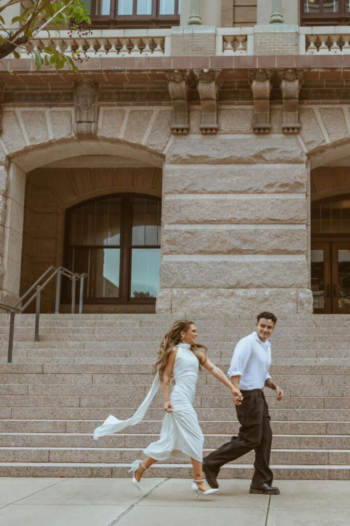 Couple running in front of the downtown courthouse during their Houston elopement