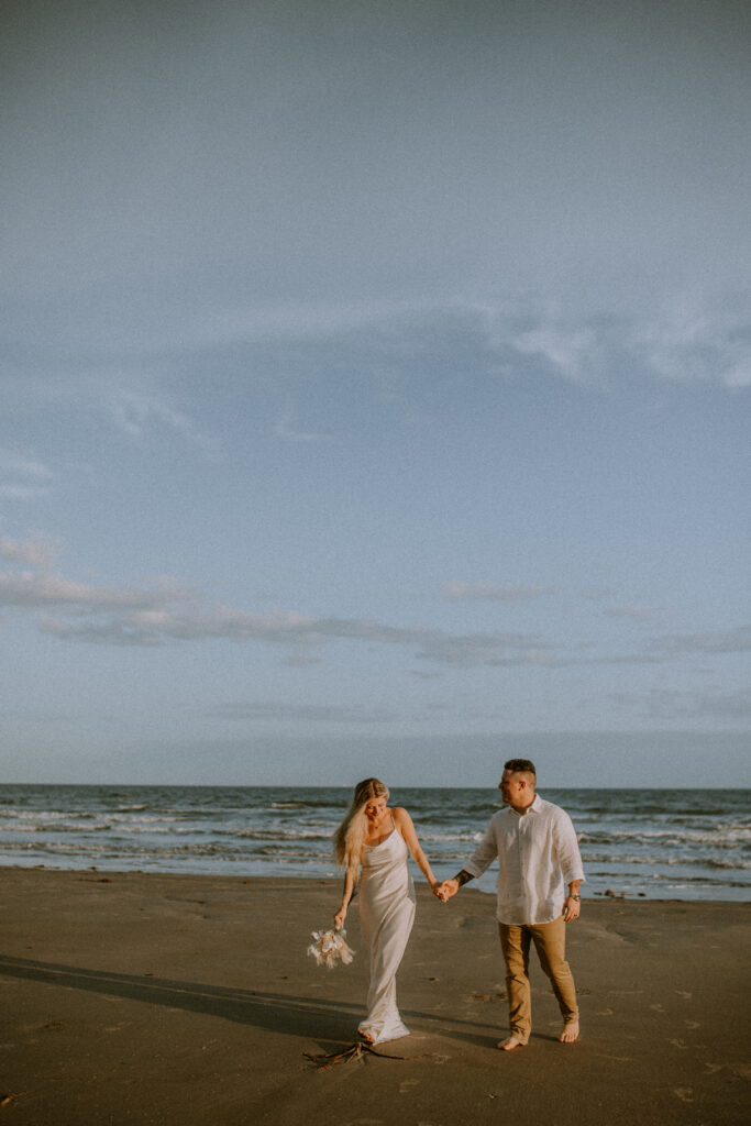 Couple walking at the beach during their elopement.