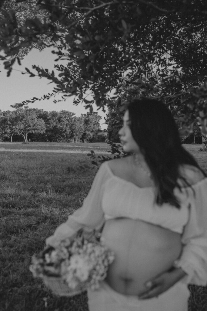 Women holding a basket with flowers during her maternity photoshoot.