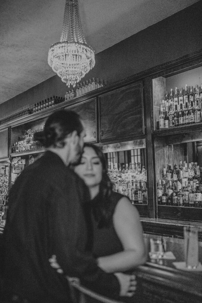 Man kissing girl on forehead while they wait for their drink at Captain Foxheart's Bad News Bar