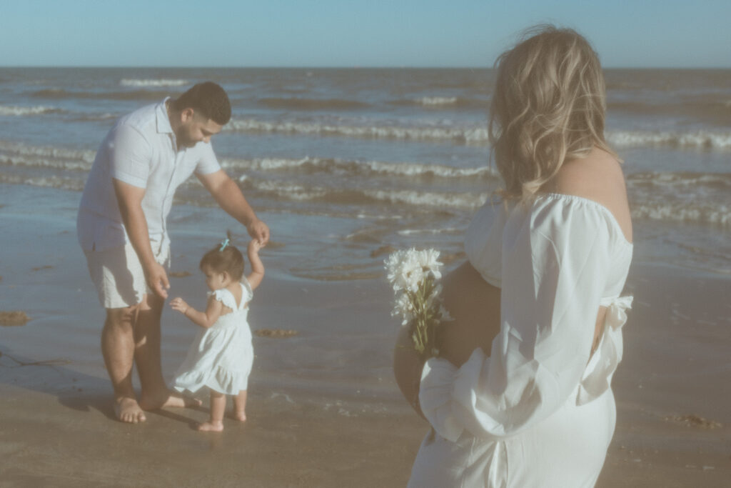 Woman looking tag her family at the beach.