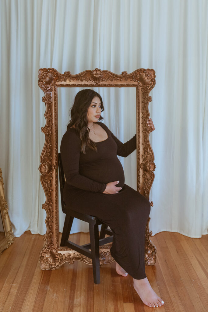 Women sitting on the chair for her maternity photoshoot.