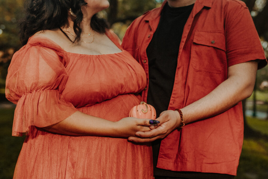 Couple holding a small pumpkin.