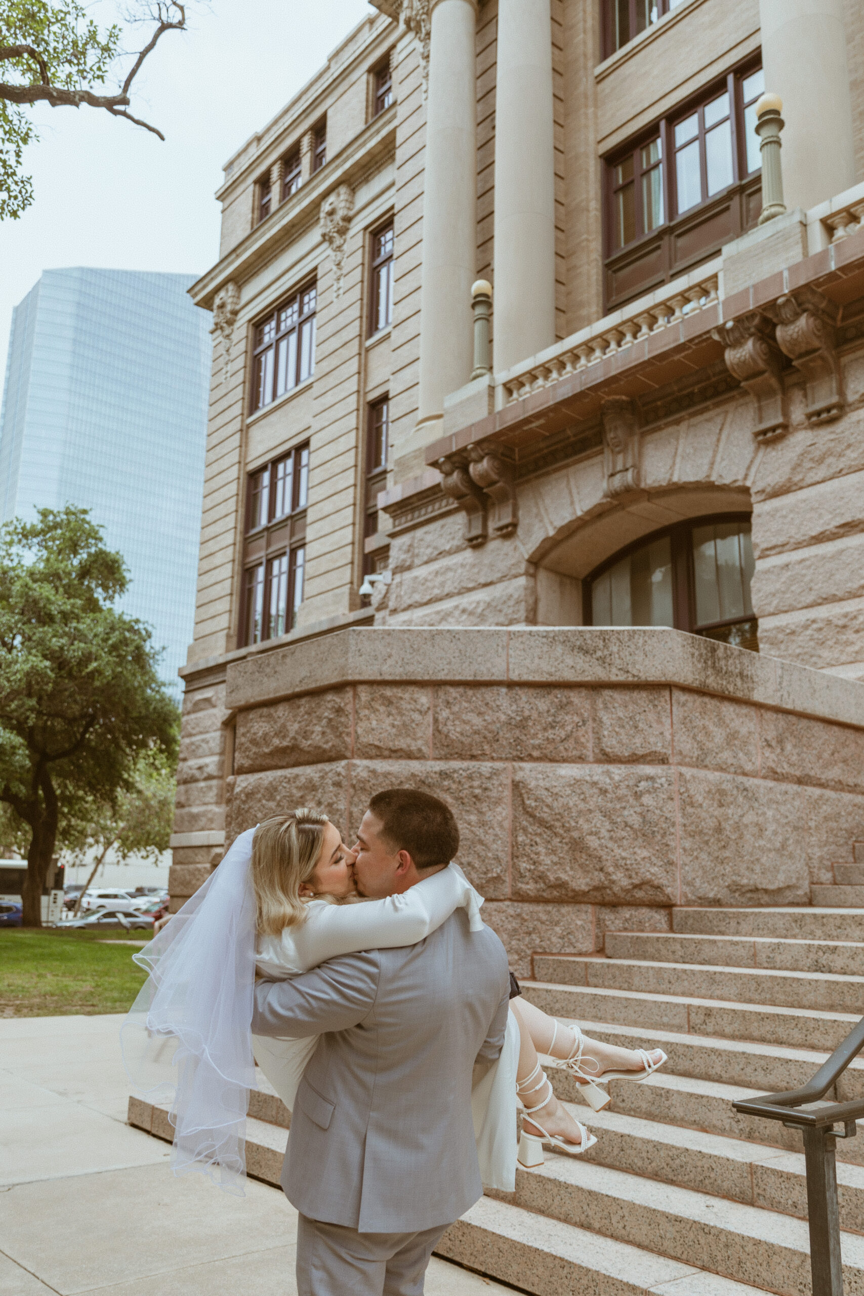 Man carrying women after their elopement at the Historic 1910 Courthouse in downtown Houston