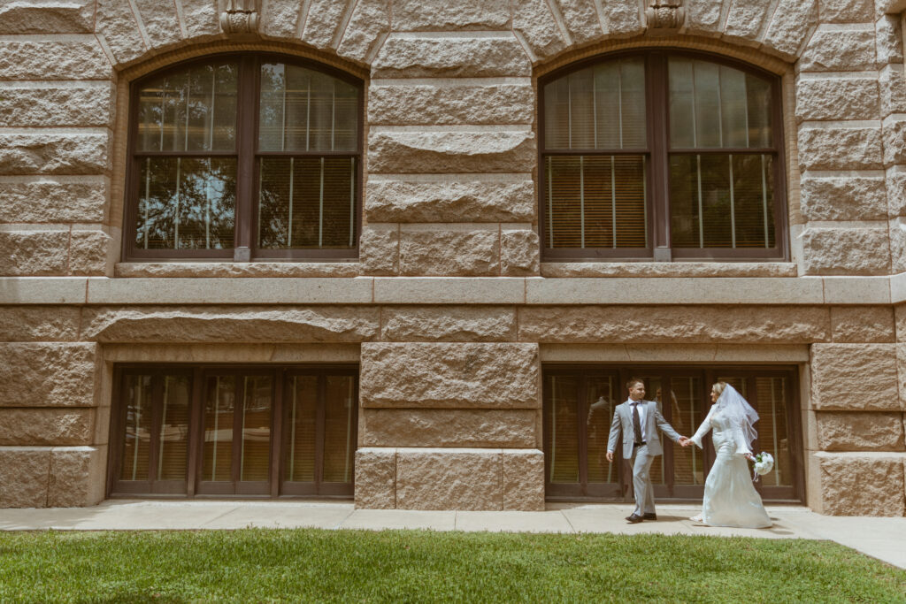 Couple holding hands walking around the Historic 1910 Courthouse in Downtown Houston