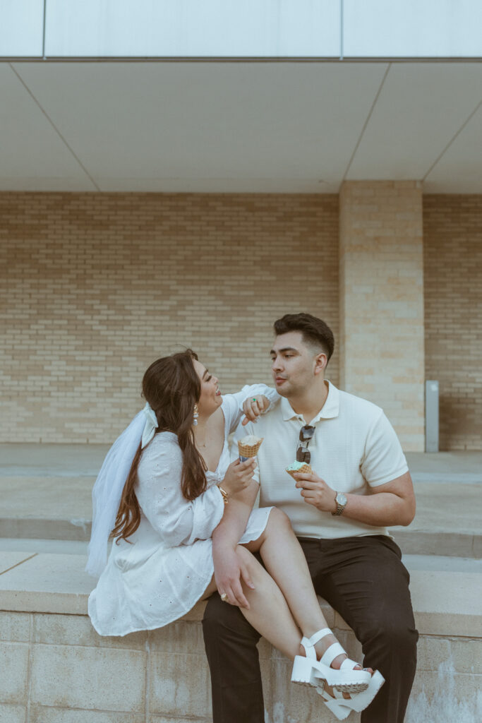 Couple sitting on a bench eating ice cream during their engagement photos