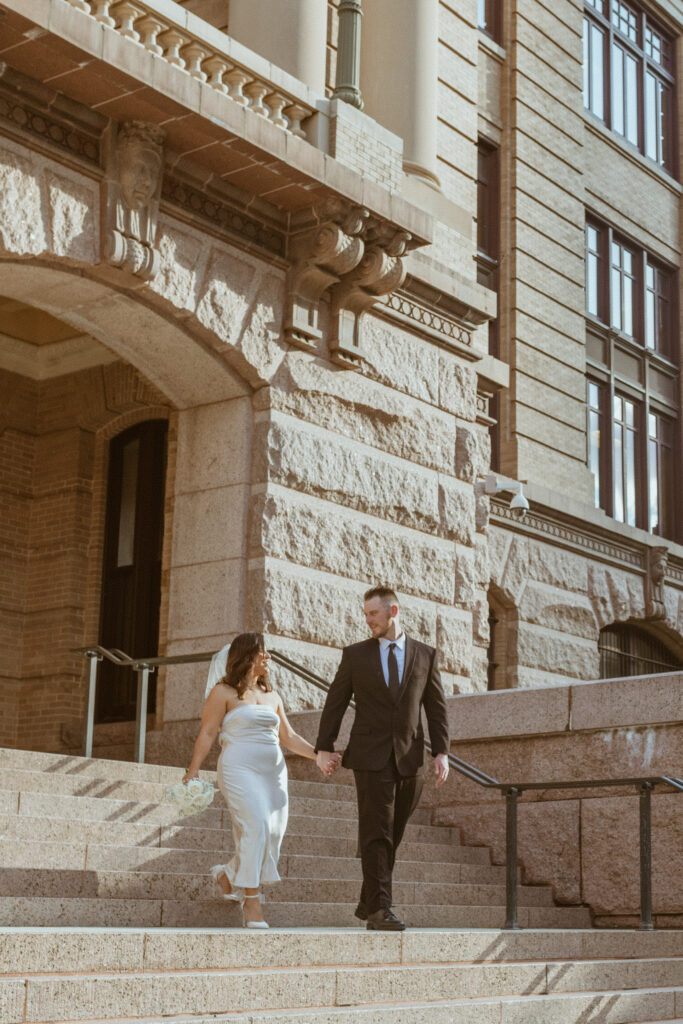 Couple walking down the stairs after their 1910 Harris County Courthouse Wedding