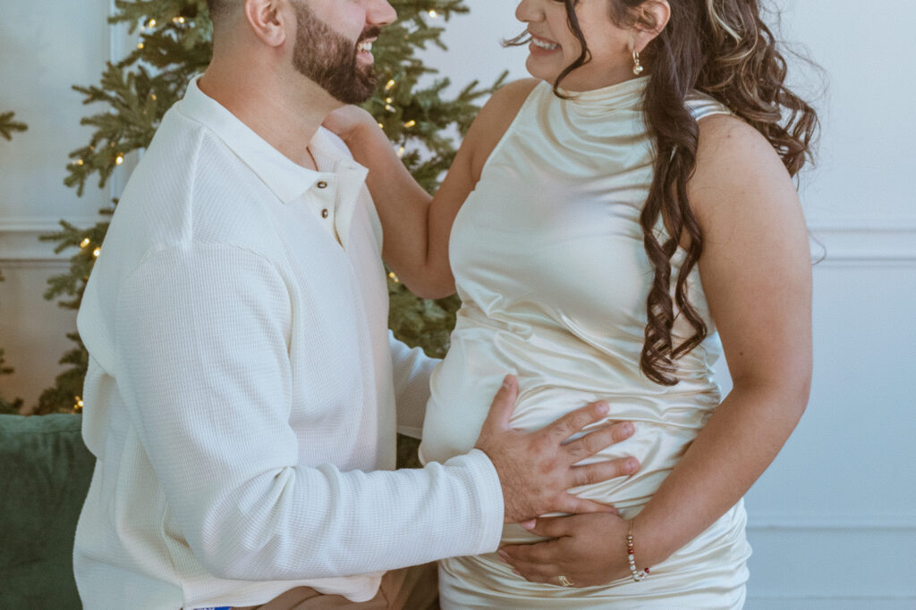 couple taking photos inside a studio for their maternity photos