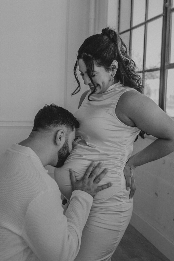 Man kneeled to kiss his wife's pregnant belly