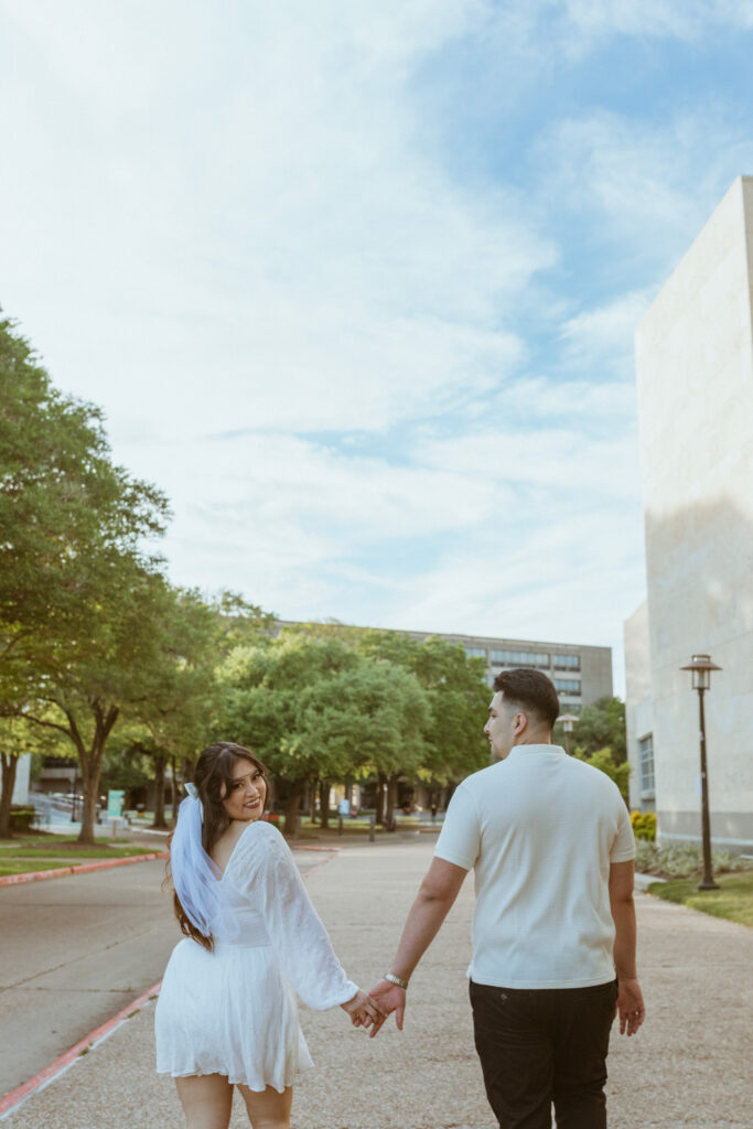 Couple walking, holding hands, at the University of Houston 