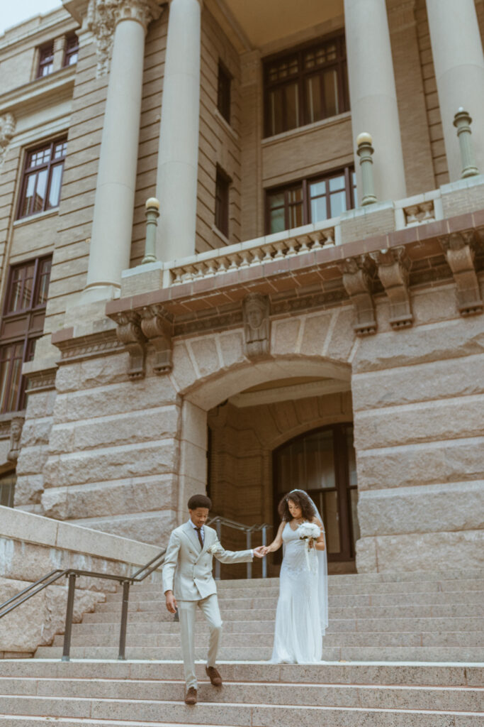 Couple walking down the stairs after their 1910 Harris County Courthouse Wedding