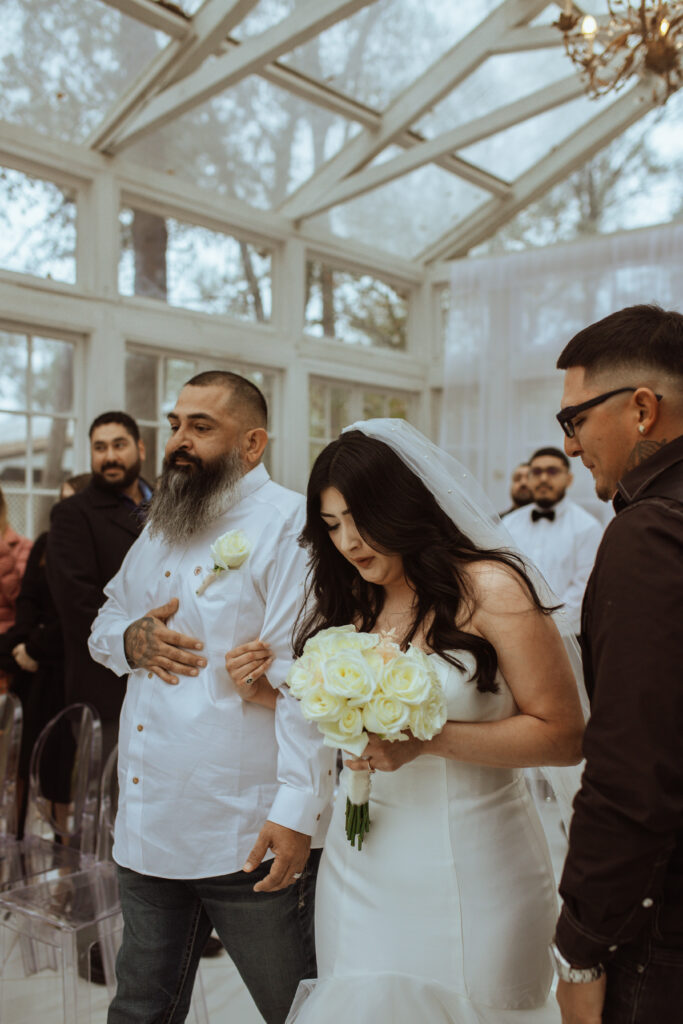 Bride and father walking down the isle during the wedding ceremony at the Oak Atelier.