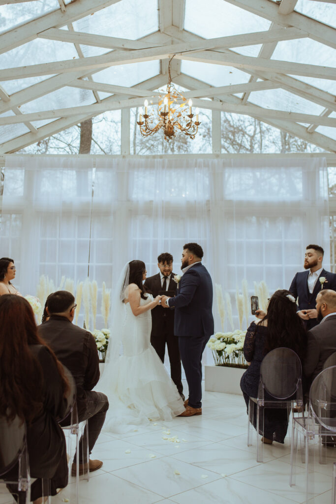 Bride and groom holding hands at the alter during their wedding ceremony