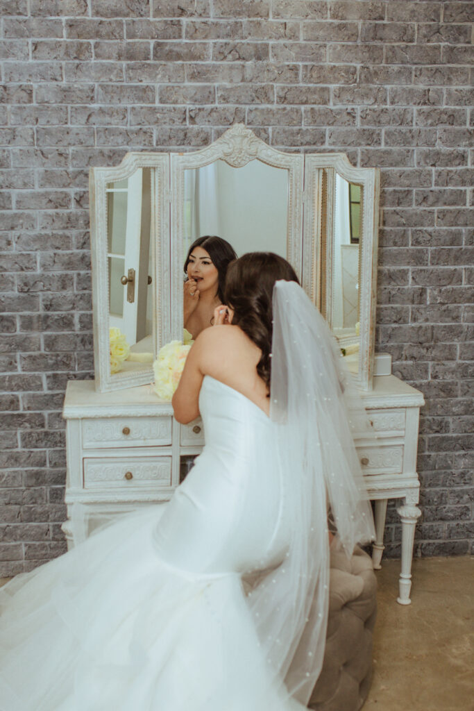 Bride applying her makeup at Oak Atelier.