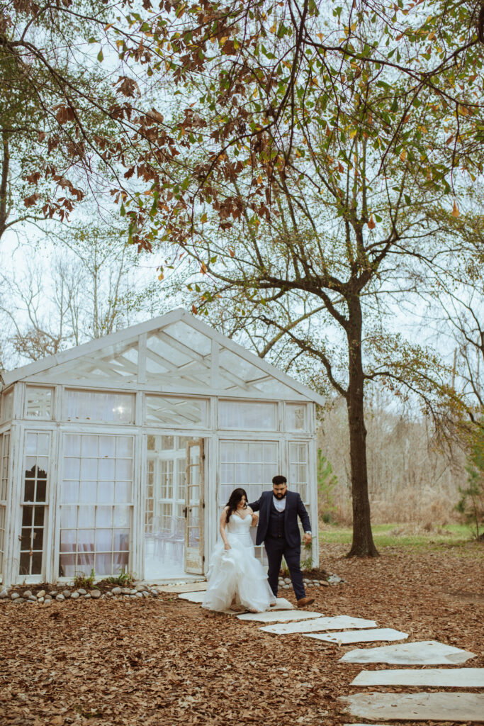 Couple walking out of the green house after their ceremony at the Oak Atelier.