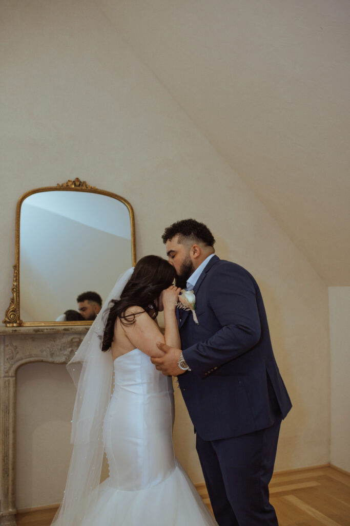 Man kissing his wife on the head during their wedding at Oak Atelier.