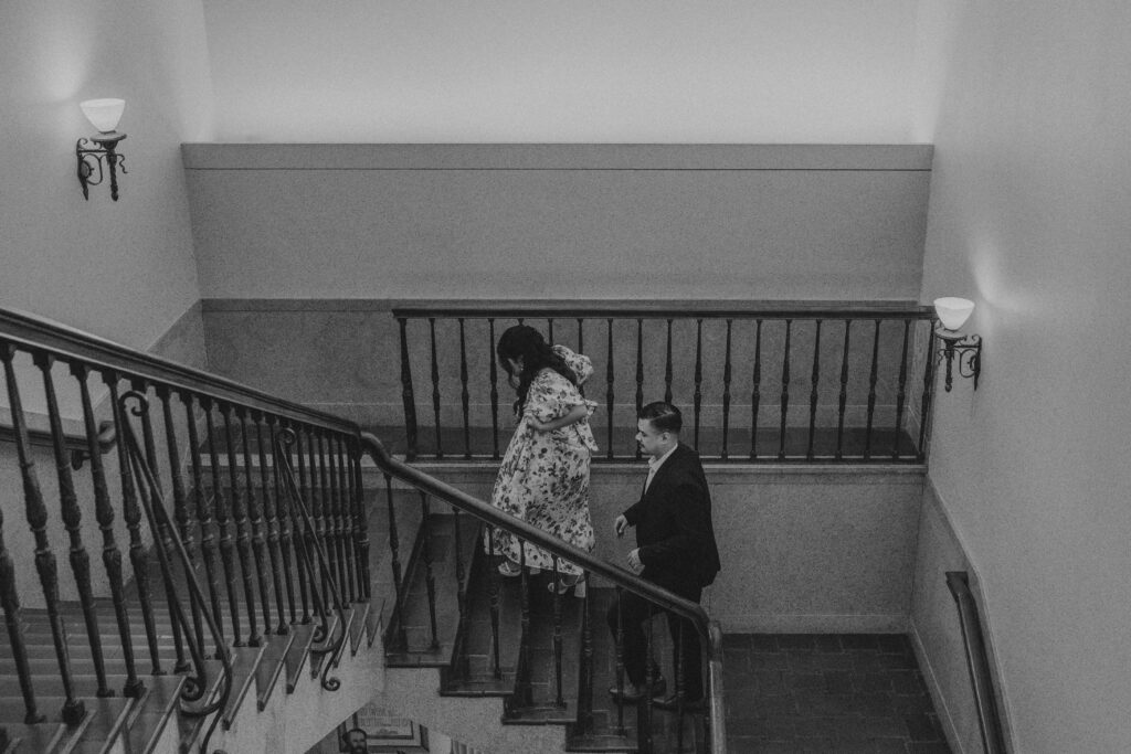 Couple walking up the stairs inside of Julia Ideson Library.