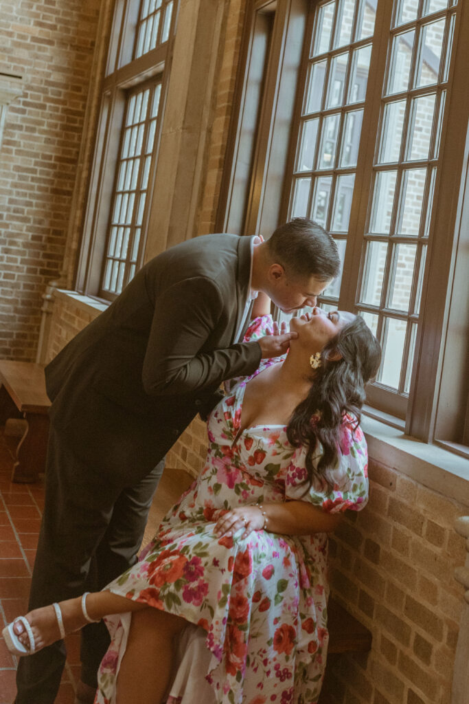 Man kissing his fiance inside the Julia Ideson Library