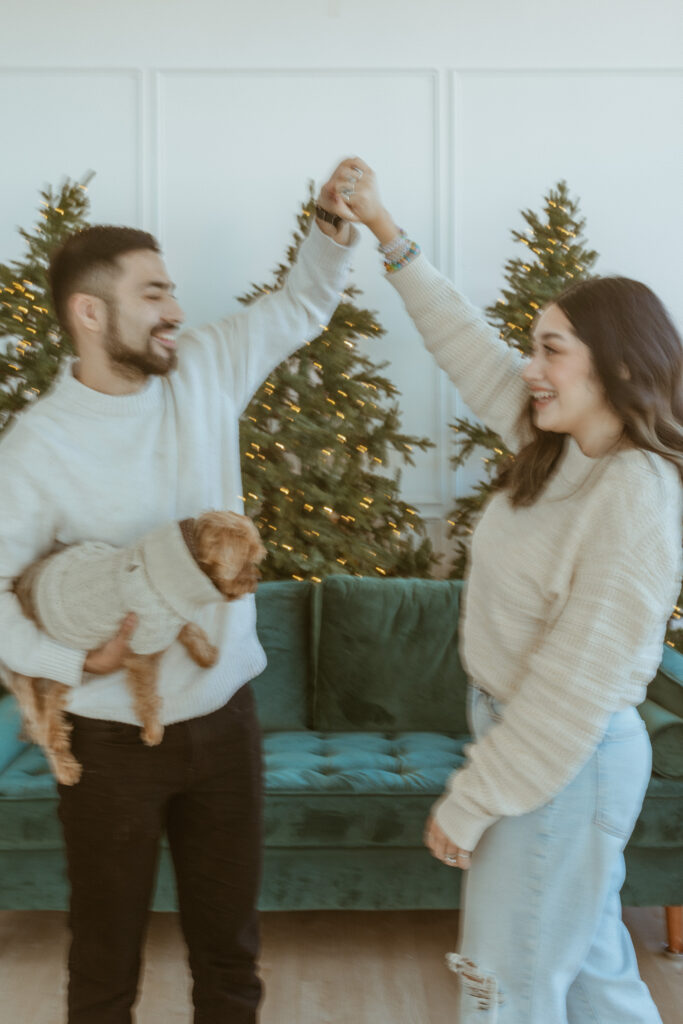 Man doing dancing turns to his girlfriend during a winter photoshoot.