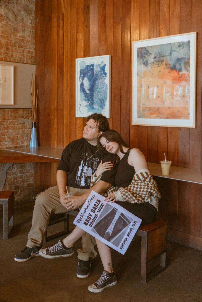 Couple sitting inside Catalina Coffee for their Pregnancy Announcement photos 