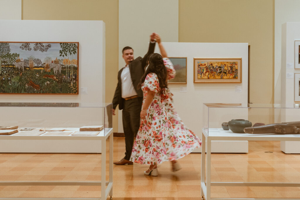 Man giving his girlfriend a dancing turn during their engagement photos.