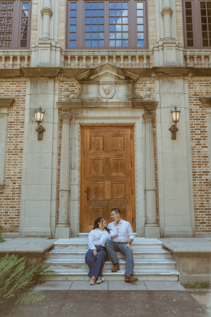 Couple sitting outside of Julia Ideson Library on the stairs. 