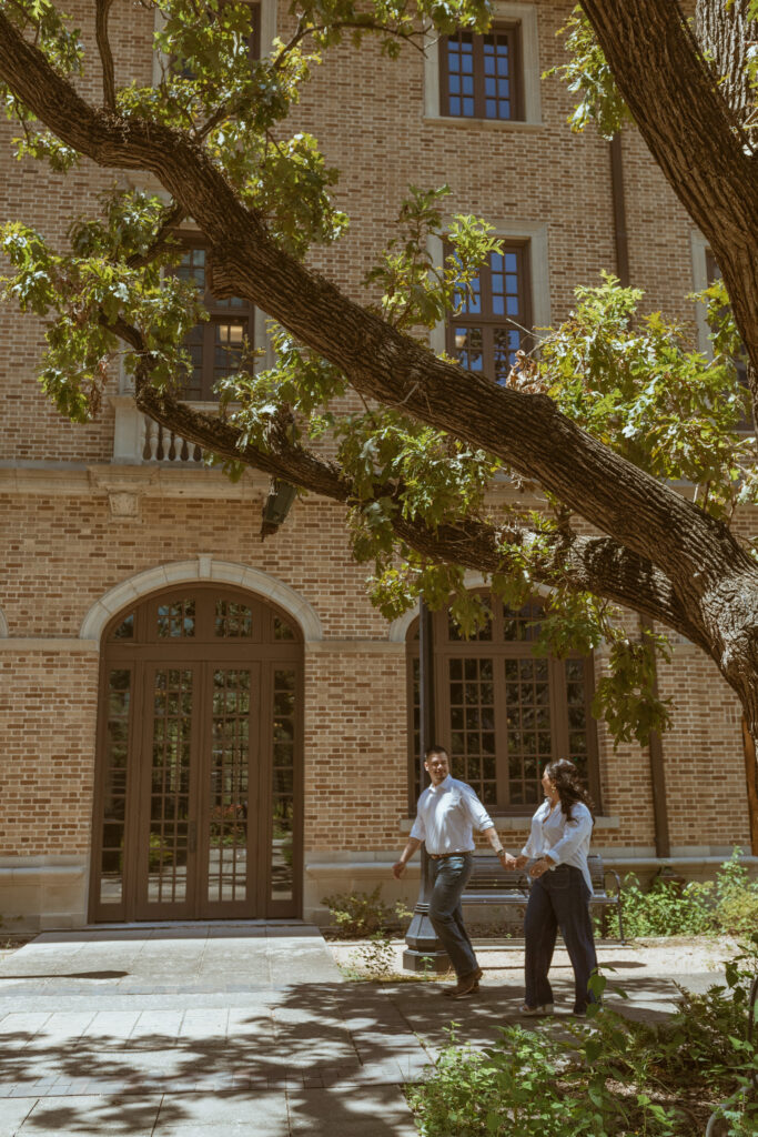 Couple, holding hands, walking outside of the Julia Ideson Library