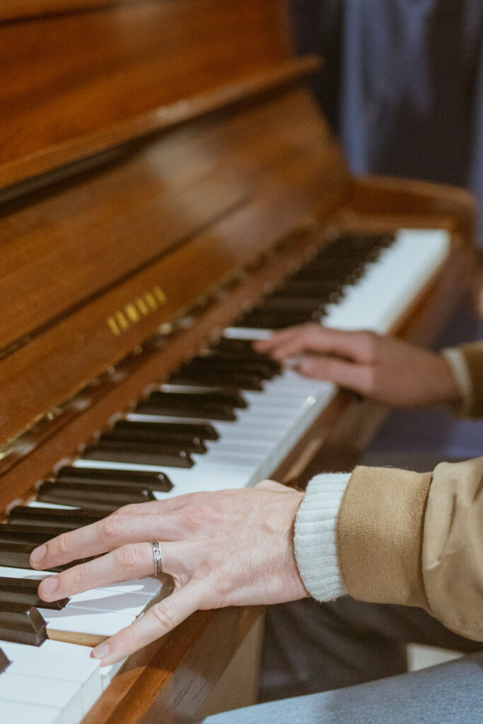 Hands playing the piano during a fall photoshoot.